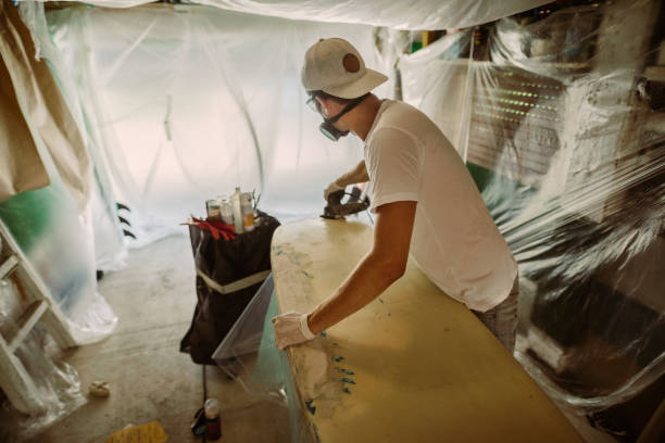 istock Young man repairing a surfboard 1181877555