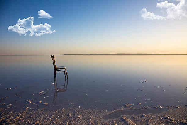 A lone chair near the sandy shore stock photo