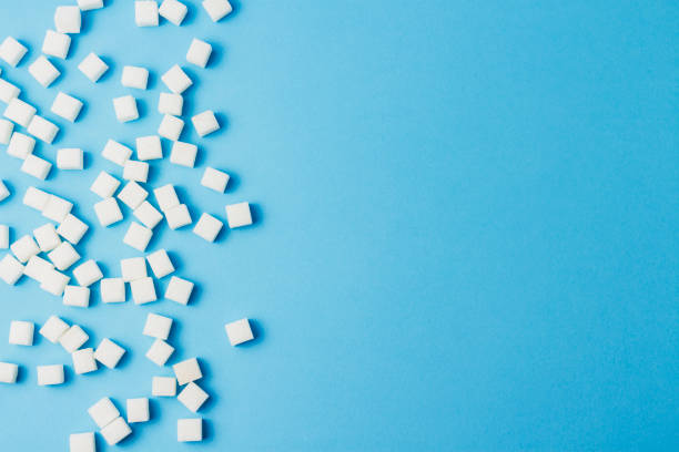 istock A lot of sugar cubes on a blue background. 1181886394