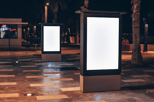 Street advertising mockup template with copy space. Two outdoor commercial banners with white empty display on the night street