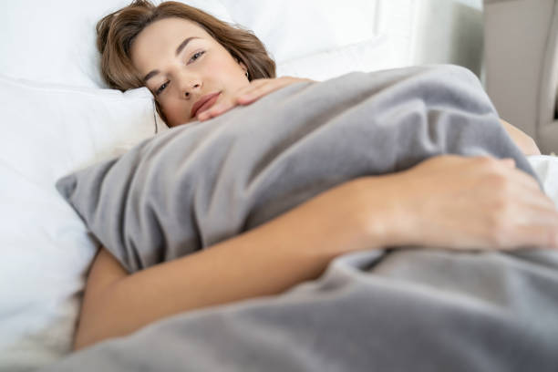 istock Tranquil pretty young lady lying in bed 1181892183