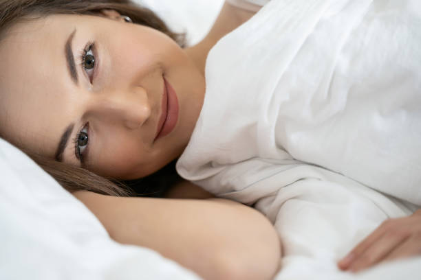 istock Smiling young Caucasian female lying in bed 1181892198