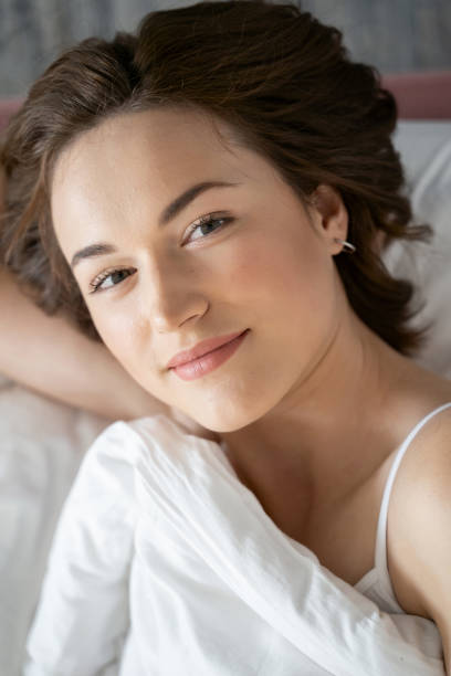 istock Cute woman in bed smiling at the camera 1181892253