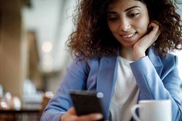 istock Young businesswoman using mobile phone at a cafe 1181892806