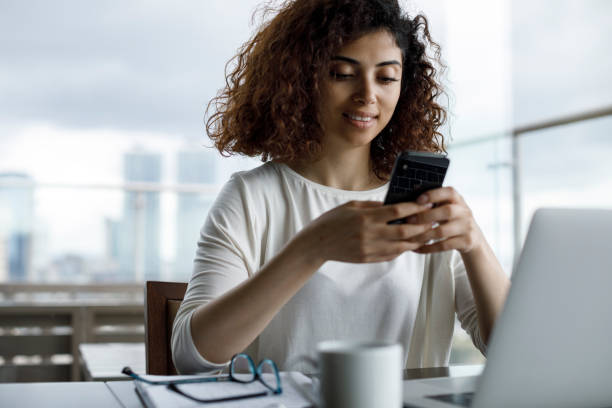 istock Smiling young woman using mobile phone 1181892961