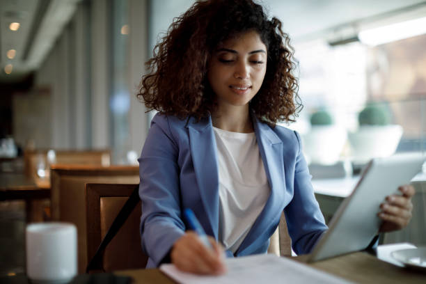 Businesswoman working at a cafe Businesswoman working at a cafe kindle stock pictures, royalty-free photos & images