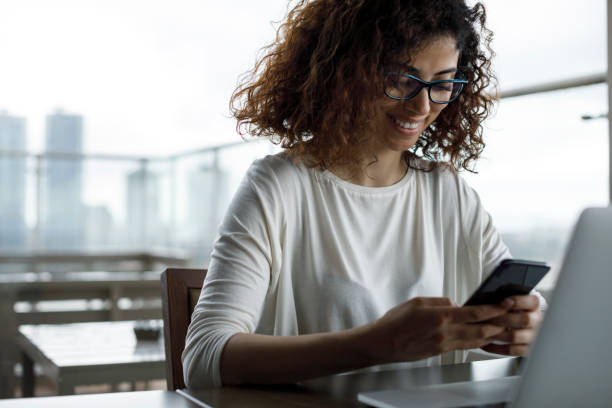 istock Smiling young woman using mobile phone 1181893418