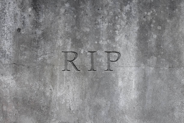 istock Old gray stone headstone with text R.I.P. carved in it 1181895190