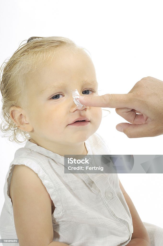 Mãe com bebê colocando hidratante's nose - Foto de stock de Bebê royalty-free
