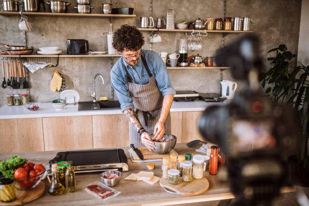 This is one of the things I love to do Camera Filming Young Man while Preparing Meat For cheeseburgers At Kitchen cooking show stock pictures, royalty-free photos & images