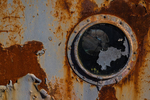 Esta es una vieja pared de hierro con un ojo de buey cubierto de corrosión - foto de stock