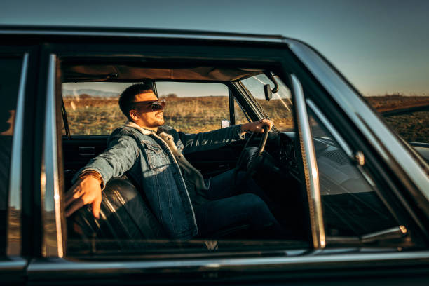 istock Macho man driving in retro car 1181902542