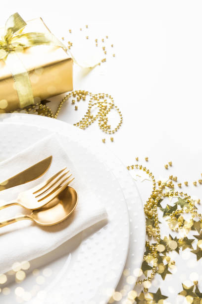 istock Christmas table setting with golden decor and light on white. 1181902864