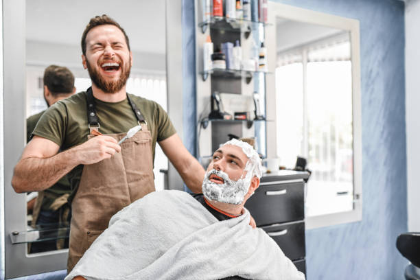 istock Customer Telling Jokes To Young Barber In Barber Shop 1181904521