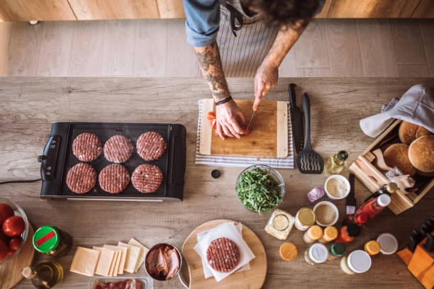 Chopping tomato and grilling burgers