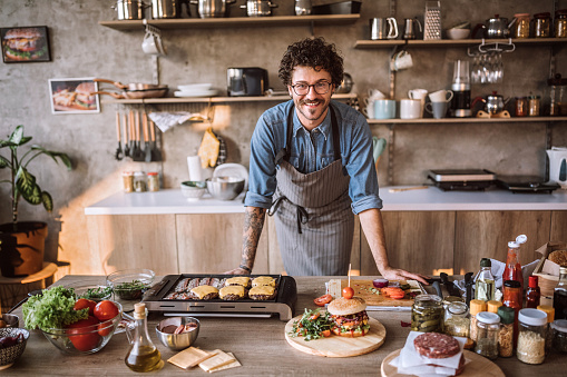 Portrait of chef in the kitchen standing and looking at camera, smiling