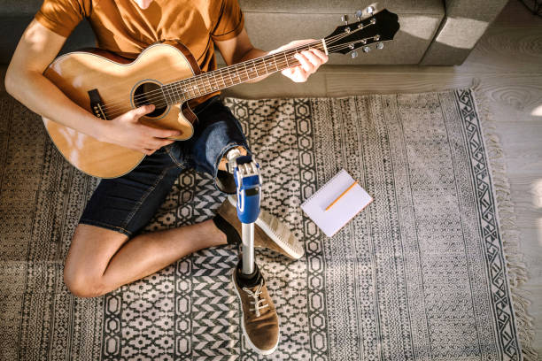 istock Man with prosthetic leg playing guitar 1181906098