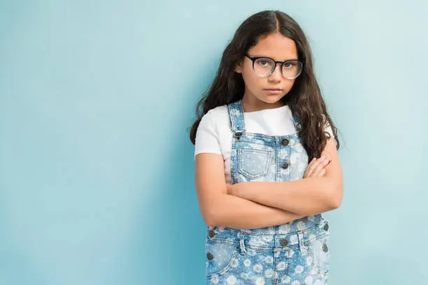 Photo of Adorable Latin Girl Staring Against Plain Background