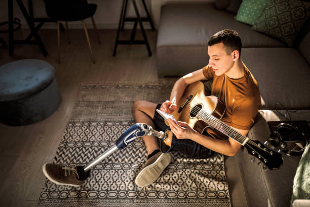 istock Young disabled musician playing acoustic guitar 1181906835