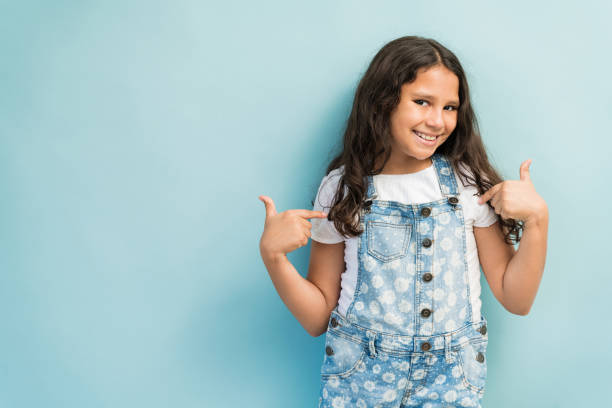 istock Girl In Overalls Gesturing Against Plain Background 1181906934