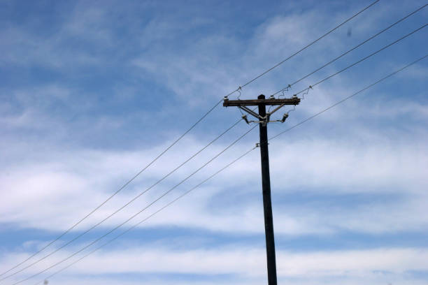 istock Utility Power Pole and Lines against Blue Sky and White Clouds 1181910408