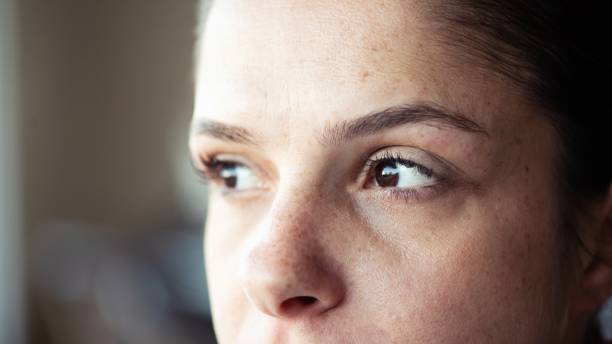 Closeup of woman looking away Extreme closeup of a freckled woman looking away. natural beauty people stock pictures, royalty-free photos & images