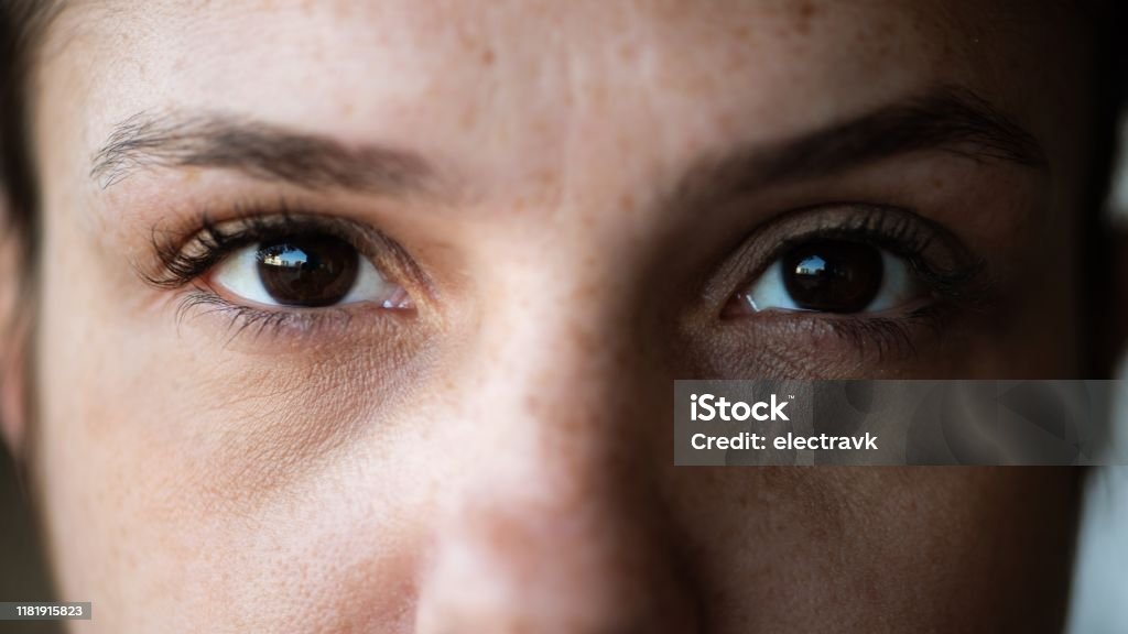 Closeup of woman looking directly at the camera Extreme closeup of a woman staring directly at the camera. Close-up Stock Photo