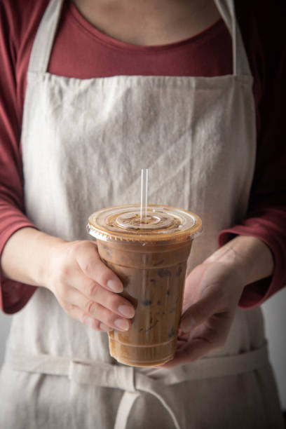istock barista serving iced coffee in plastic cup 1181926253