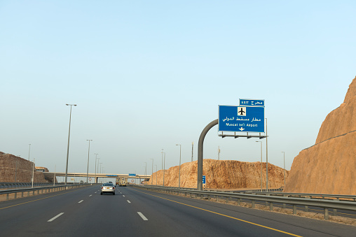 A street sign points to the exit leading to the Muscat International Airport in Oman