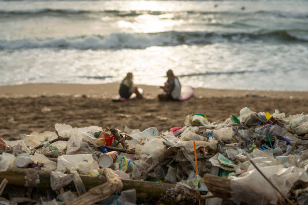 śmieci i surferów na plaży w kuta, bali - kuta beach zdjęcia i obrazy z banku zdjęć