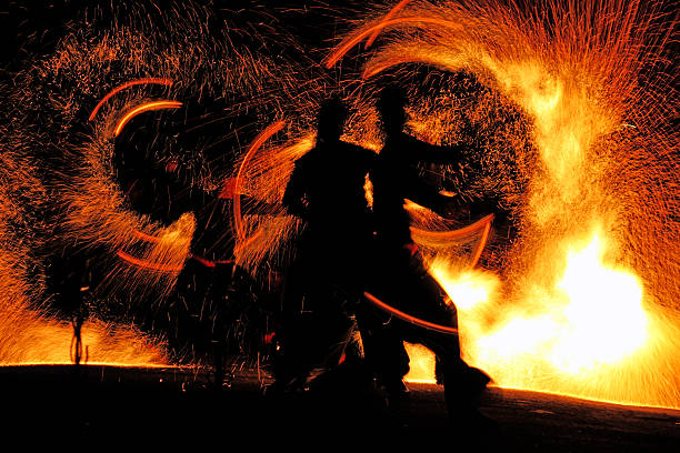 A fire show at night with flames flying stock photo