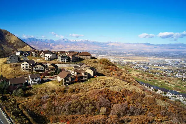 An aerial autumn scene of homes atop a mountain overlooking Salt Lake Valley in Utah, USA.