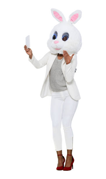 One person / full length of 20-29 years old adult beautiful black hair / long hair latin american and hispanic ethnicity female / young women businesswoman / business person wearing businesswear / business casual / smart casual / mask - disguise / costume / a suit who is humor / bizarre / wearing a rabbit mask una persona / longitud completa de 20-29 años de edad adulto hermoso pelo negro / pelo largo latino y etnia hispana mujer / mujeres jóvenes empresaria / persona de negocios que lleva un traje que es humor / extraño / usando una máscara de conejo