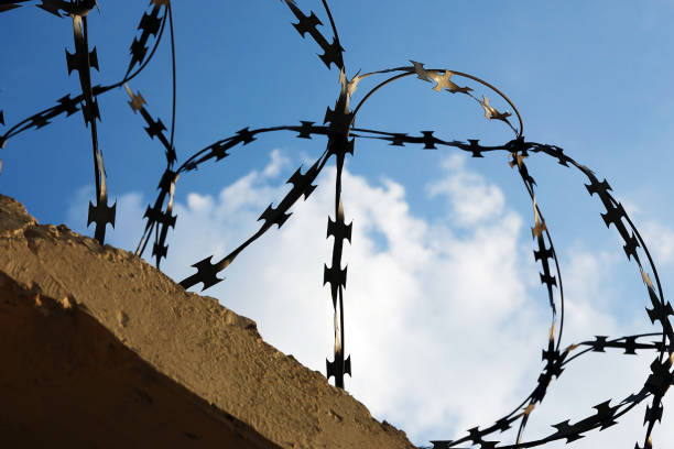 istock Razor wire in blue sunny sky. Lockdown symbol 1181935606