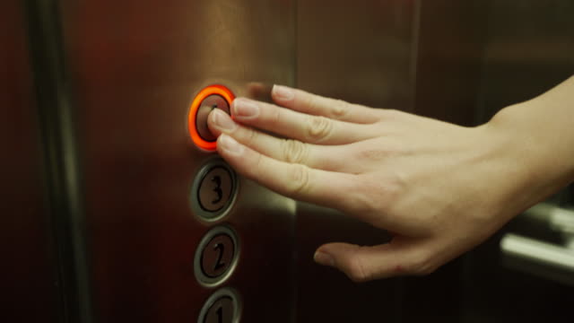 Woman hand pushing elevator button