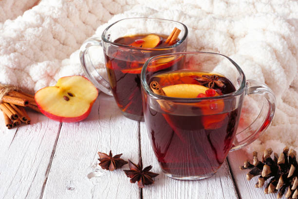 jesienna przyprawiona herbata z jabłkami i granatami, widok z boku na tle białego drewna z przytulnym kocem - tea winter autumn heat zdjęcia i obrazy z banku zdjęć