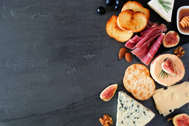 istock Assorted cheeses and meats, top view side border on a dark background with copy space 1181945388