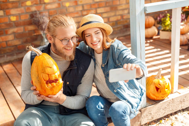 młodzi dorośli przyjaciele robiący selfie z halloweenową dynią - two jack zdjęcia i obrazy z banku zdjęć