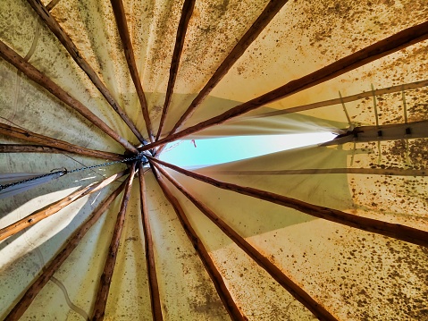 Inside of a teepee looking up at the smoke hole window