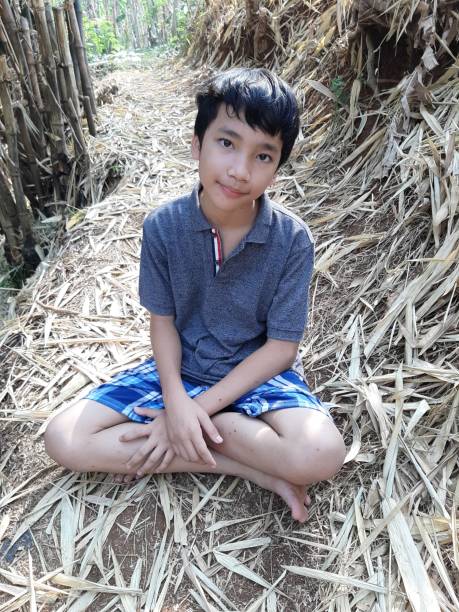 istock Two Young Indonesian Twin Boys are Off the Path and Exploring the Field. 1181955352