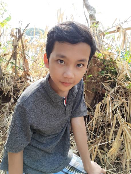 istock Two Young Indonesian Twin Boys are Off the Path and Exploring the Field. 1181955394