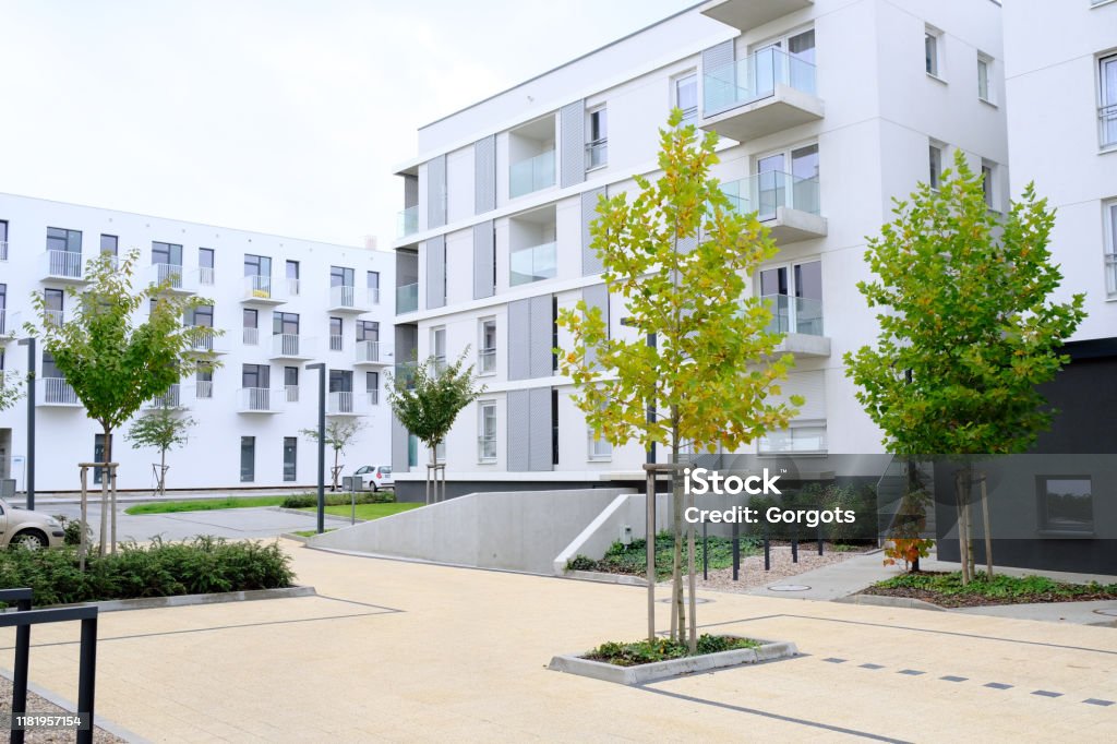 Sidewalk in a cozy courtyard of modern apartment buildings condo with white walls.  No people. Real estate business concept. Courtyard Stock Photo