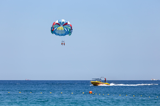Puerto Galera, Sabang, Philippines - April 4, 2017: Two people parasailing in a blue sky