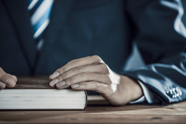 istock Businessman sitting with a thick book 1181961388