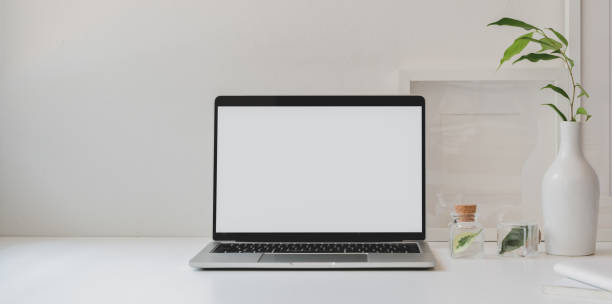 istock Mock up laptop computer in minimal workspace with copy space and ceramic vase 1181972078