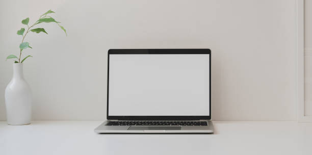 istock Mock up laptop computer in minimal workspace with copy space and ceramic vase 1181972147