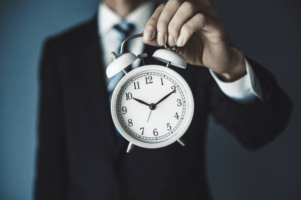 istock Businessman holding an alarm clock 1181976354