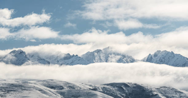 istock Panoramic snow mountains with white clouds and blue sky in winter 1181980292