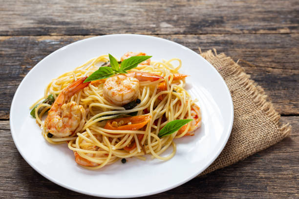 istock Spaghetti with spicy fried shrimp on a wooden table 1181986223