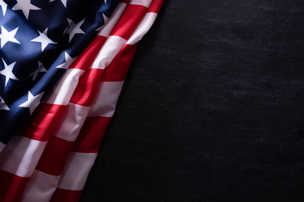 istock Happy Veterans Day. American flags veterans against a blackboard background. 1181987888